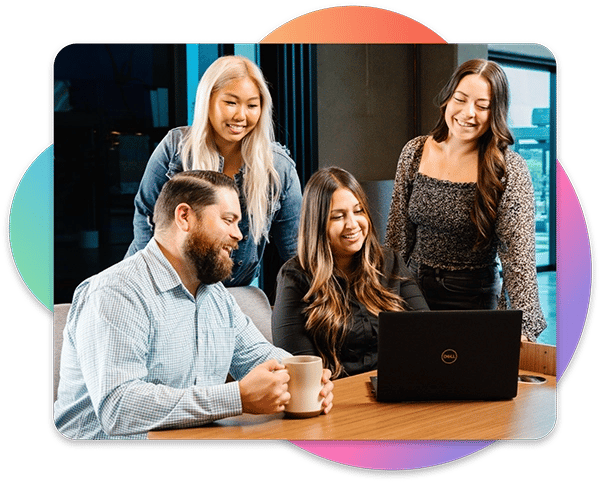 Group of 4 TCWGlobal workers looking at a laptop